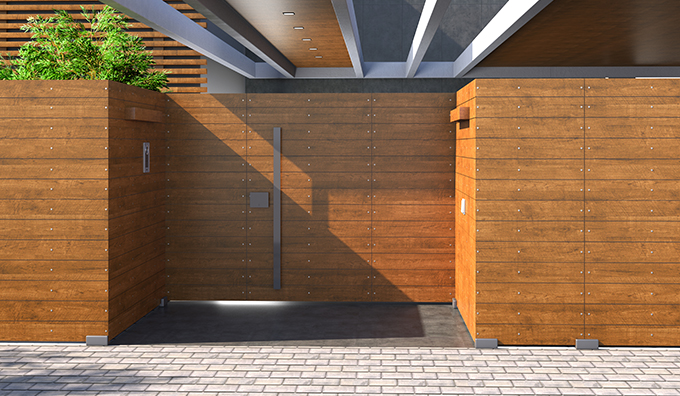 A modern building facade featuring warm, vertically installed wood-grain textured cladding panels, illuminated by a contemporary wall light.